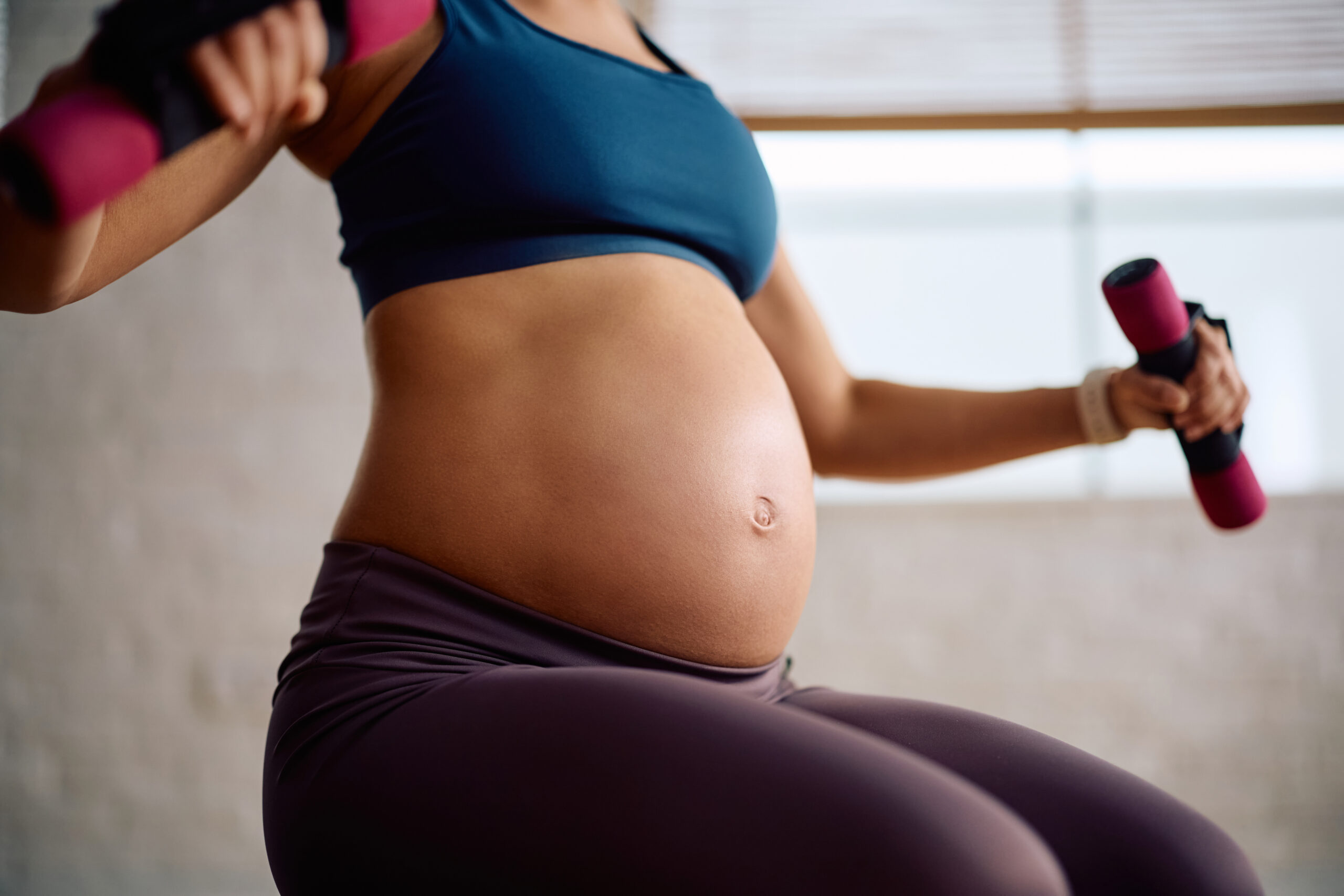 close up of mother to be using dumbbells while wor 2026 03 26 10 34 36 utc