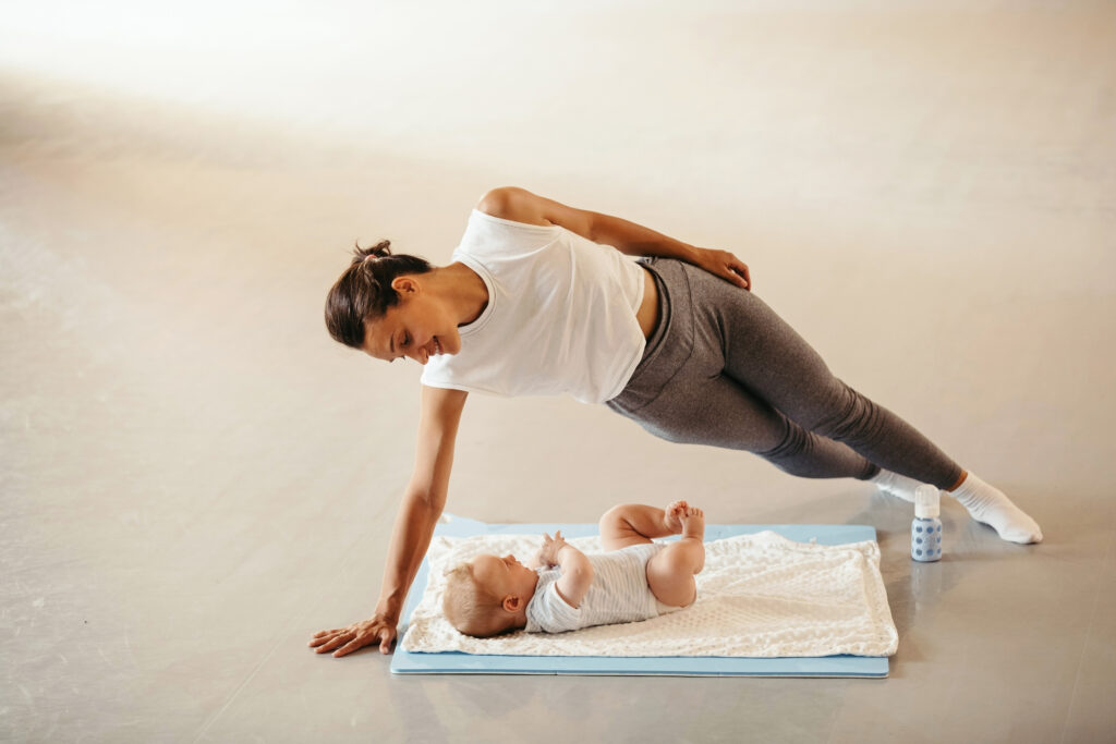 happy mother with baby practicing one hand push up 2026 01 06 10 28 08 utc